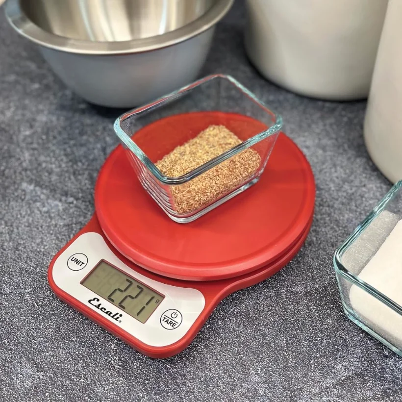 A red Telero weighing spices into a glass dish